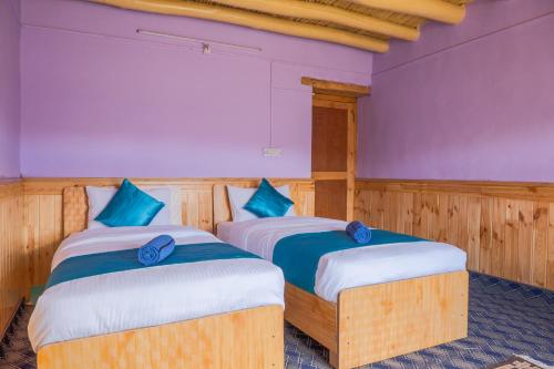 two beds in a room with purple and blue at RezangLa Border Homestay in Chushul