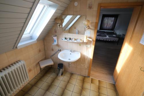 W łazience znajduje się umywalka i lustro. w obiekcie Hotel Sonnenmatte Titisee B und B nahe Badeparadies w mieście Titisee