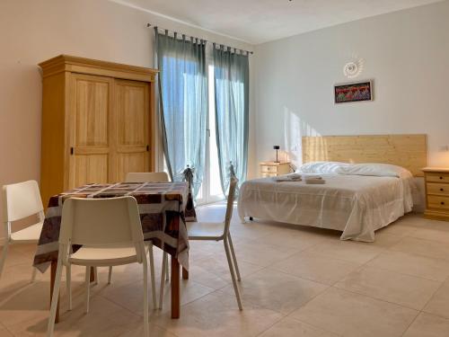 1 dormitorio con 1 cama, mesa y sillas en Villa Dinesh, en Chioggia