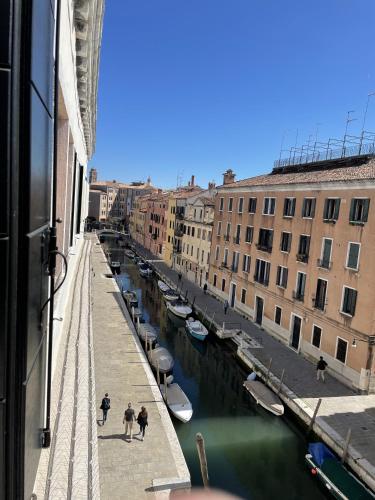 a group of people walking along a canal with boats at Casa Caburlotto in Venice