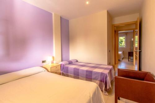 2 camas en una habitación con paredes moradas en Catalunya Casas Costa Brava Relax and Recharge 20km from beach!, en Sils
