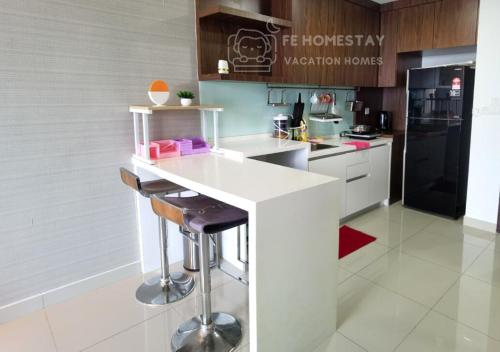 a kitchen with a white counter and a black refrigerator at Netflix WiFi Cozy Homestay Trefoil Setia Alam Shah Alam 沙亚南舒适温馨日租民宿 in Setia Alam