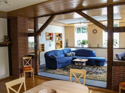 ein Wohnzimmer mit einem blauen Sofa und einem Tisch in der Unterkunft Ferienwohnung Drewitz in Schmallenberg