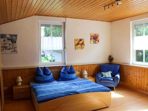 een slaapkamer met een bed en twee blauwe stoelen bij Ferienwohnung Drewitz in Schmallenberg