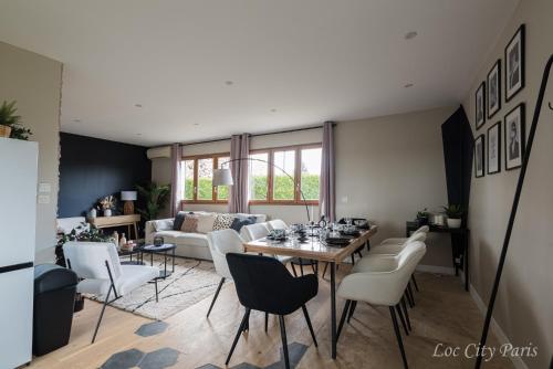un salon avec une table et des chaises dans l'établissement Maison de Charme - Parc Asterix - proche Mer de Sable - Villepinte - Aéroport CDG, à Ermenonville