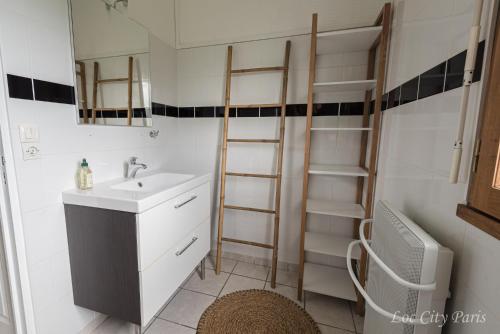 a bathroom with a sink and a mirror and shelves at Maison de Charme - Parc Asterix - proche Mer de Sable - Villepinte - Aéroport CDG in Ermenonville