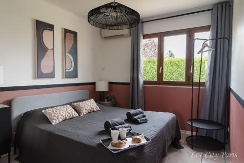 a bedroom with a bed with a tray of food on it at Maison de Charme - Parc Asterix - proche Mer de Sable - Villepinte - Aéroport CDG in Ermenonville
