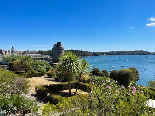a garden with a view of the water and boats at Villa Sainte Claire in Saint Malo