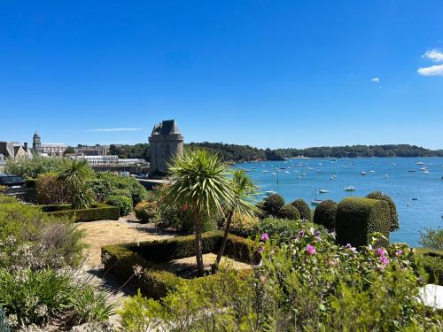 einen Garten mit Blick auf das Wasser und die Boote in der Unterkunft Villa Sainte Claire in Saint-Malo