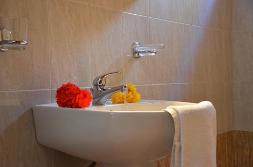 a bathroom sink with a flower on top of it at Stegnailion in Archangelos