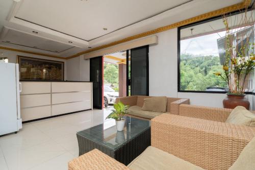 een woonkamer met een bank en een tafel bij Urbanview Hotel Gunung Geulis Village by RedDoorz in Bogor