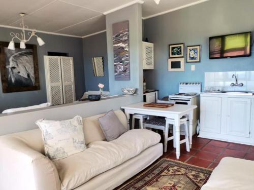 sala de estar con sofá y cocina en Schafli Manor Wild Coast, en Chintsa