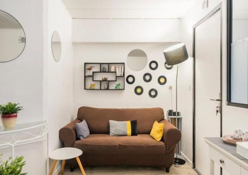 a living room with a brown couch and a table at Chambres privées dans maison avec jardin-Proche LDLC-Groupama Stadium-Eurexpo in Vaulx-en-Velin