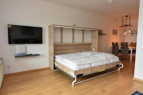 a bedroom with a bed and a flat screen tv at Haus "Panorama" Appartement PAN087 in Duhnen