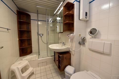 a bathroom with a sink and a shower and a toilet at Haus "Panorama" Appartement PAN087 in Duhnen