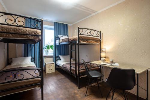 a room with two bunk beds and a desk and a deskablish at Хостел єЖитло Щекавиця in Kyiv
