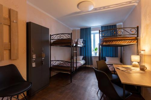 a room with two bunk beds and a table and chairs at Хостел єЖитло Щекавиця in Kyiv