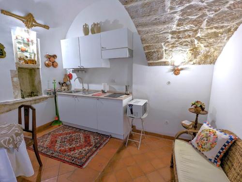a kitchen with a sink and white cabinets in a room at La Casa Delle Fate in Siracusa