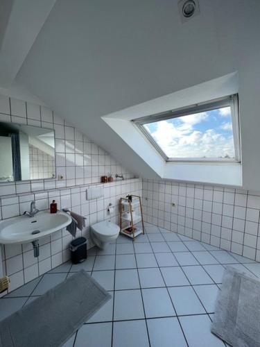 a bathroom with a sink and a toilet and a window at Nachtquartier Münster in Münster
