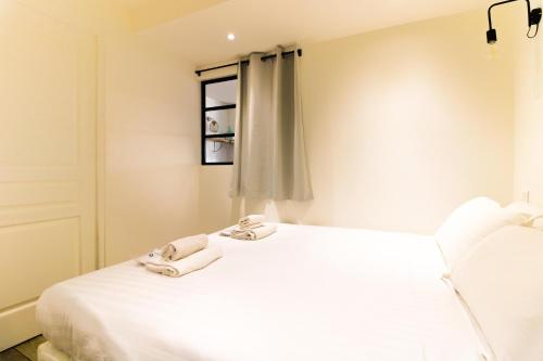 a bedroom with a white bed and a window at SELECT'SO HOME - T2 au cœur du Lavandou - Prestations de qualité - GAIA in Le Lavandou