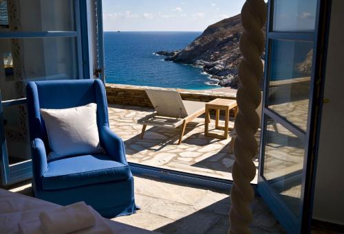 een slaapkamer met uitzicht op de oceaan vanaf een balkon bij Aegea Blue Cycladic Resort in Zorgos 