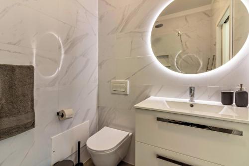 uma casa de banho com um WC branco e um espelho. em Casa Homem do Mar em Paul do Mar