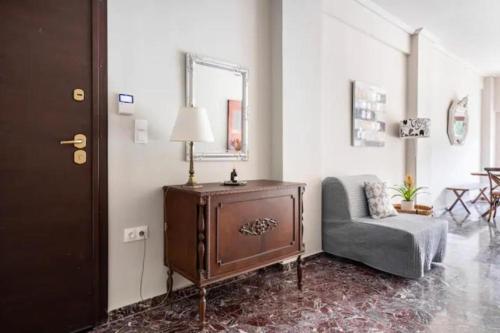 a living room with a chair and a table at Flisvos Marina refurbished apartment in Athens