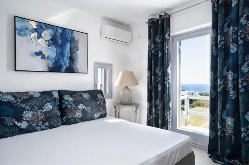 a bedroom with a bed and a large window at Alfa Luxury Villas in Chrissi Akti