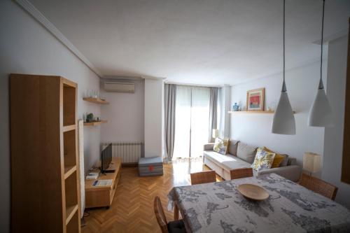 sala de estar con mesa y sofá en Flat with parking in the center of Las Rozas en Las Rozas de Madrid