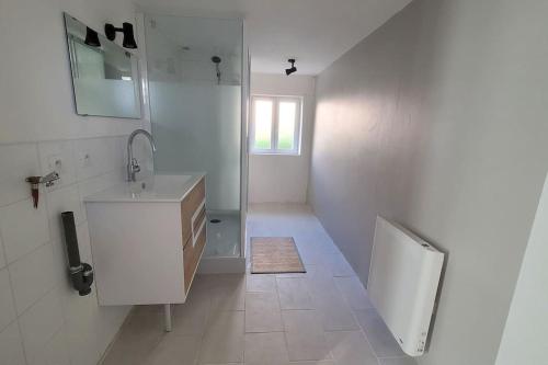 a white bathroom with a sink and a mirror at Domaine de la Harpe in Bossay-sur-Claise