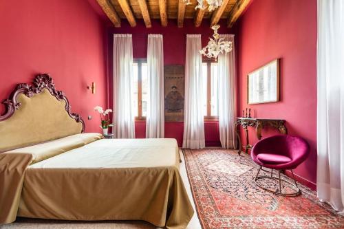 Dormitorio rojo con cama y pared de color rosa en Cà Regina Panada - passion on the Canal en Venecia