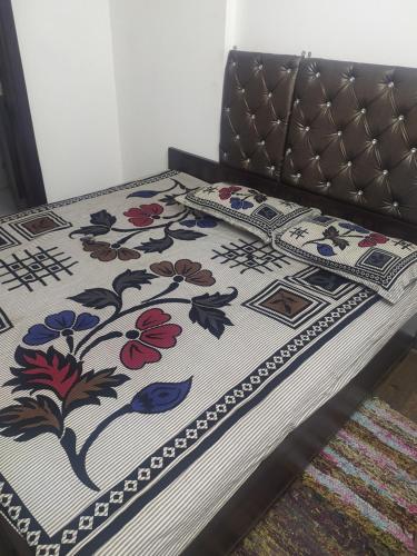 Una cama con una manta con flores. en Pukhraj element en Kota