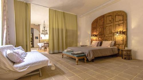 sypialnia z dużym łóżkiem i kanapą w obiekcie Catalunya Casas Breathtaking 18th Century Converted Convent! w mieście Vilarrodona