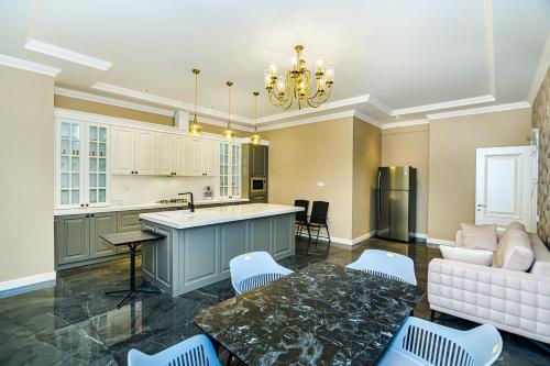 バクーにあるSweet Property on Trump Palaceのキッチンとテーブルとソファのあるリビングルーム