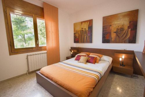 ein Schlafzimmer mit einem Bett mit zwei Lampen und einem Fenster in der Unterkunft Catalunya Casas A Cozy Catalan hideaway just 30min from Sitges! in Piera