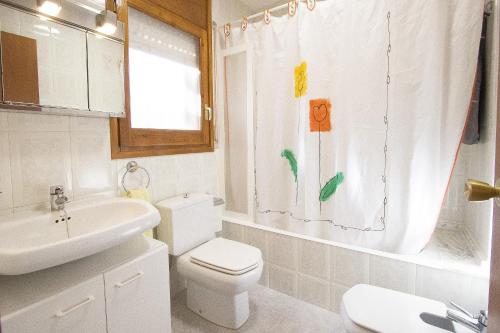 a bathroom with a toilet and a sink and a shower curtain at Catalunya Casas A Cozy Catalan hideaway just 30min from Sitges! in Piera