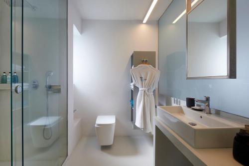 a bathroom with a sink and a toilet and a shower at Alti Santorini Suites - Caldera View in Megalochori