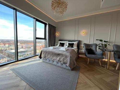 Schlafzimmer mit einem Bett und großen Fenstern in der Unterkunft Hanza Tower HOME4U in Stettin