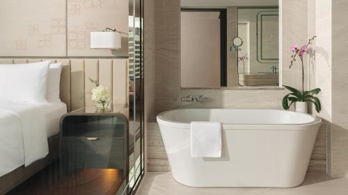 a bathroom with a bath tub next to a bed at InterContinental Bangkok, an IHG Hotel in Bangkok