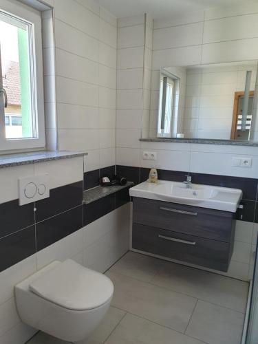 a bathroom with a toilet and a sink and a mirror at Gästehaus Martha in Rust