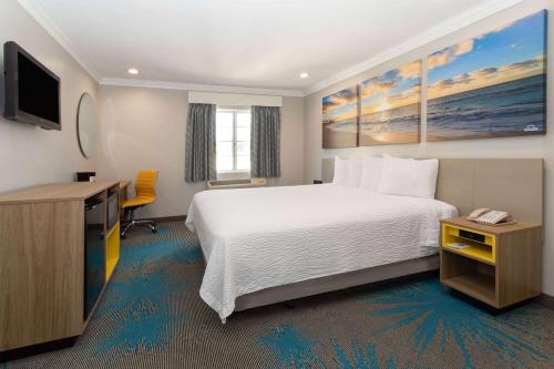 ロサンゼルスにあるDays Inn by Wyndham Santa Monicaのベッドとテレビが備わるホテルルームです。