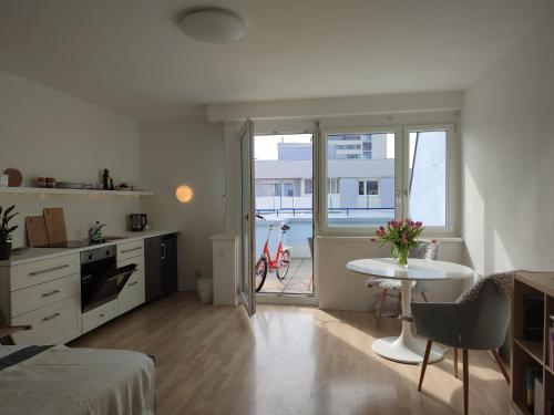 a room with a bed and a table and a kitchen at Studio mit Terrasse in zentraler Lage in Graz