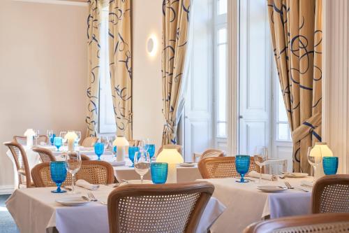 a row of tables in a restaurant with blue glasses at PortoBay Serra Golf in Santo da Serra