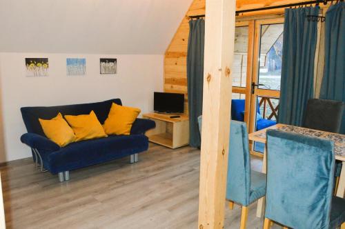 uma sala de estar com um sofá azul e almofadas amarelas em DoliAnna em Krasnobród