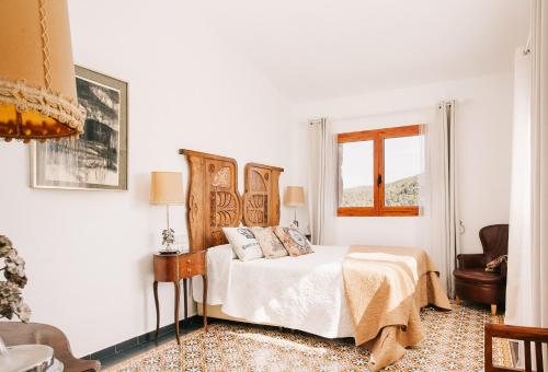een witte slaapkamer met een bed en een raam bij Catalunya Casas Wow! Boutique hotel converted into a private villa! in Rubio