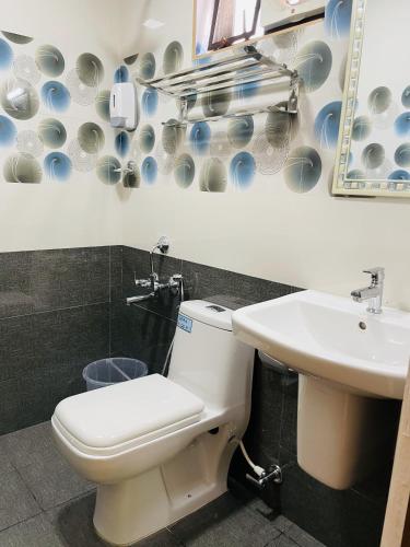 a bathroom with a toilet and a sink at Hotel Signature Cochin in Cochin