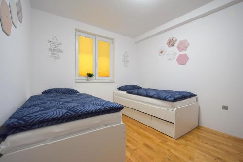 - une chambre avec 2 lits et une fenêtre dans l'établissement Apartment Lana, à Soline