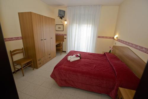 a bedroom with a red bed and a desk at Hotel Ganfo in Sirmione