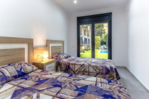 a bedroom with two beds and a window at Catalunya Casas Modern Vacation Paradise 'Villa Ainmi' on the Costa Brava! in Sils