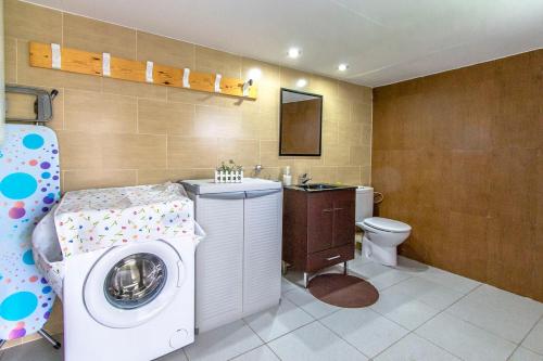 Un baño con lavadora y lavabo. en Catalunya Casas Modern Vacation Paradise 'Villa Ainmi' on the Costa Brava!, en Sils